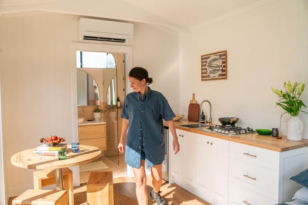 Interior of an Outhaus module with kitchen, timber table and raked ceiling
