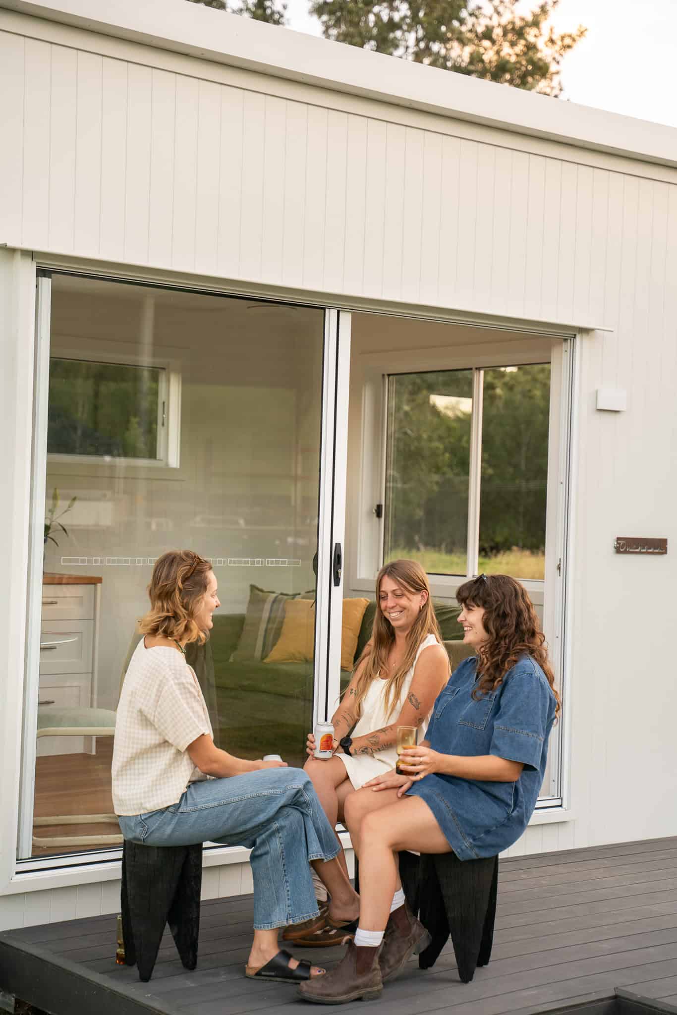 Three friends talking on the deck of an Outhaus module