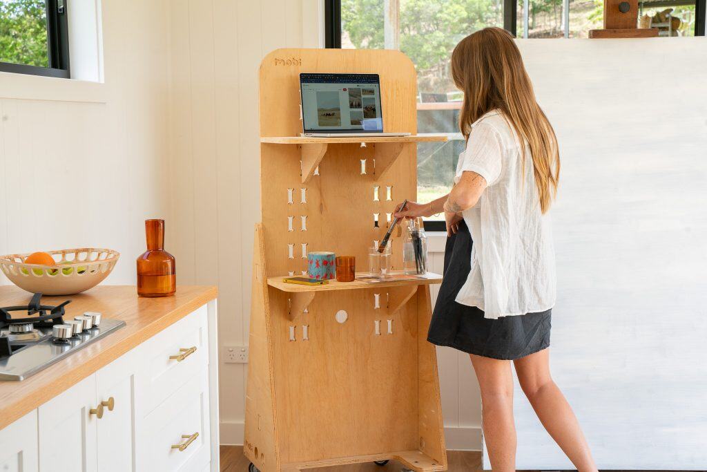 Person at a timber storage and workspace unit inside an Outhaus module