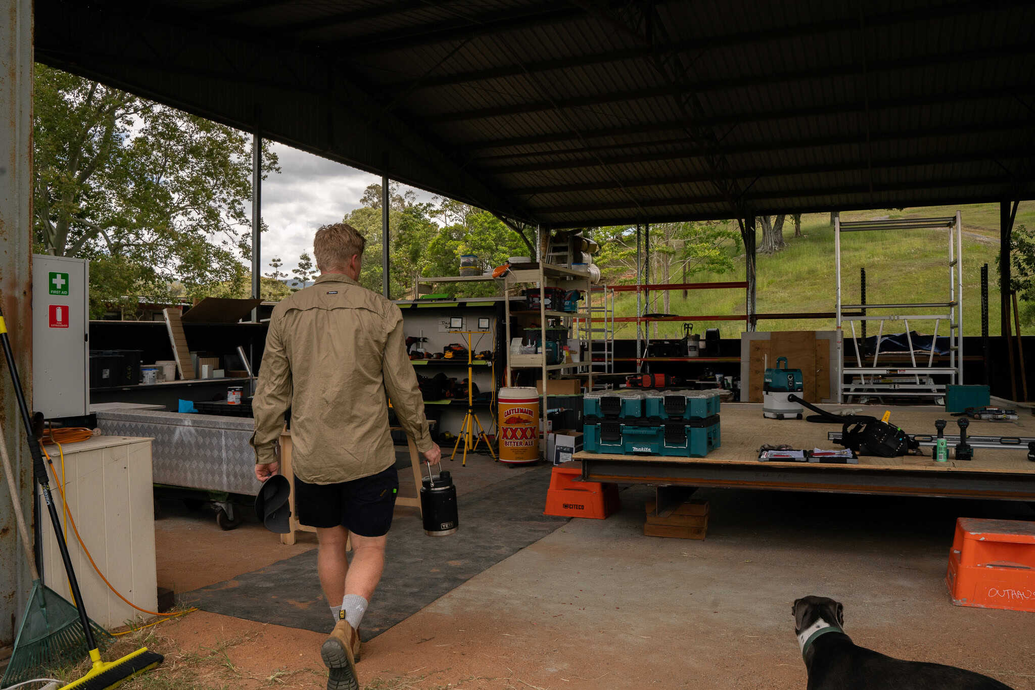 Looking into the open build shed at Laceys Creek, tools laid out on a module deck and hills behind