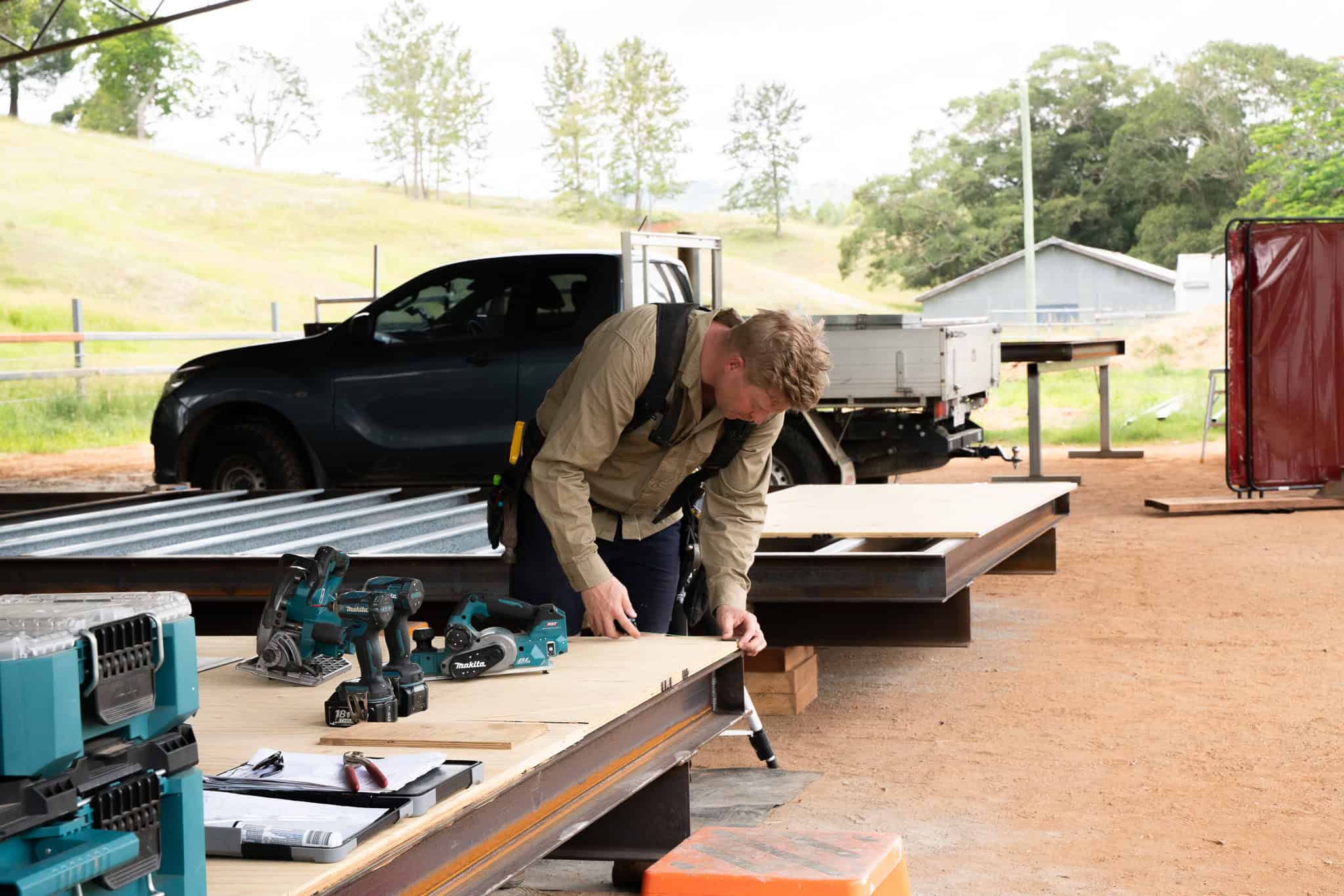The Outhaus crew building a steel floor frame under the shed roof at Laceys Creek